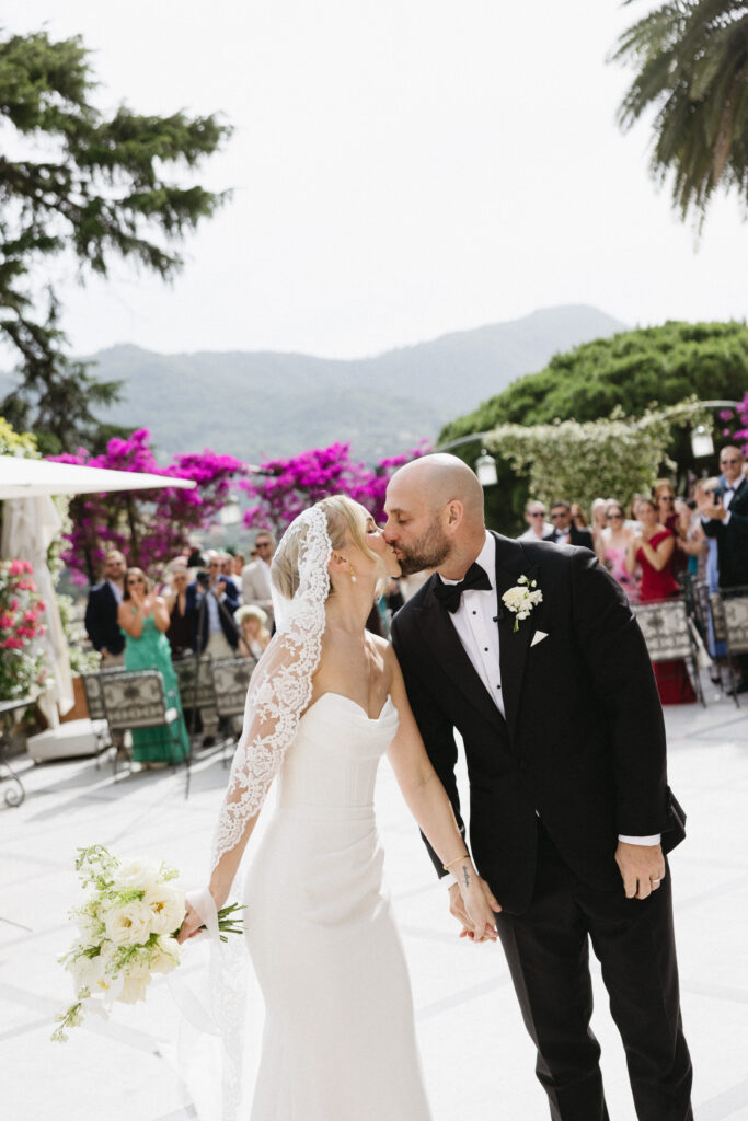 Bride and groom kissing while walking down the aisle after their Imperiale Palace Hotel wedding ceremony
