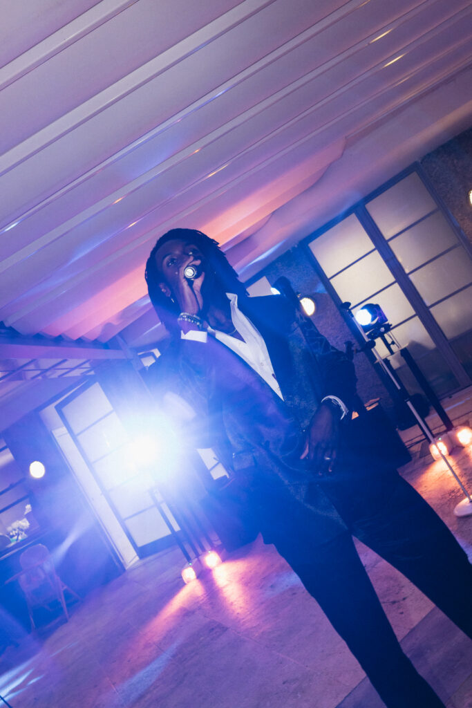 Performer singing under purple stage lighting at the Imperiale Palace Santa Margherita Ligure wedding reception